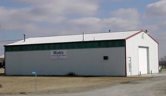 Exterior of the Watts Vault & Monument Company facility in Chariton, Iowa, with the company name on the building.