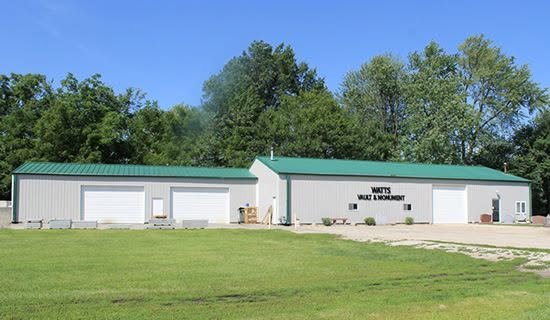 Watts Vault & Monument Company showroom building in Montezuma, Iowa, with the company name on the front.